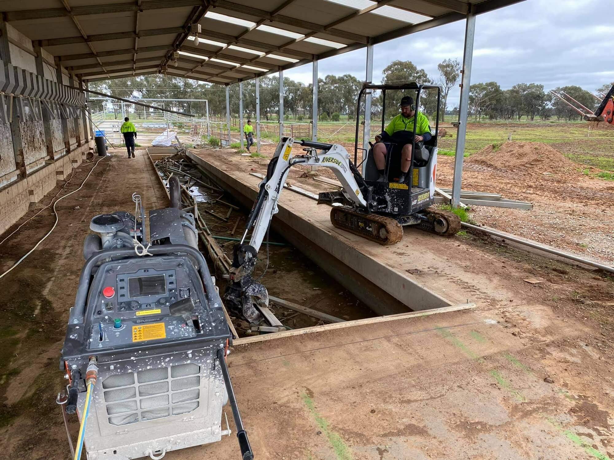 Saw cut trench opened through a shed floor slab ready for services to go in