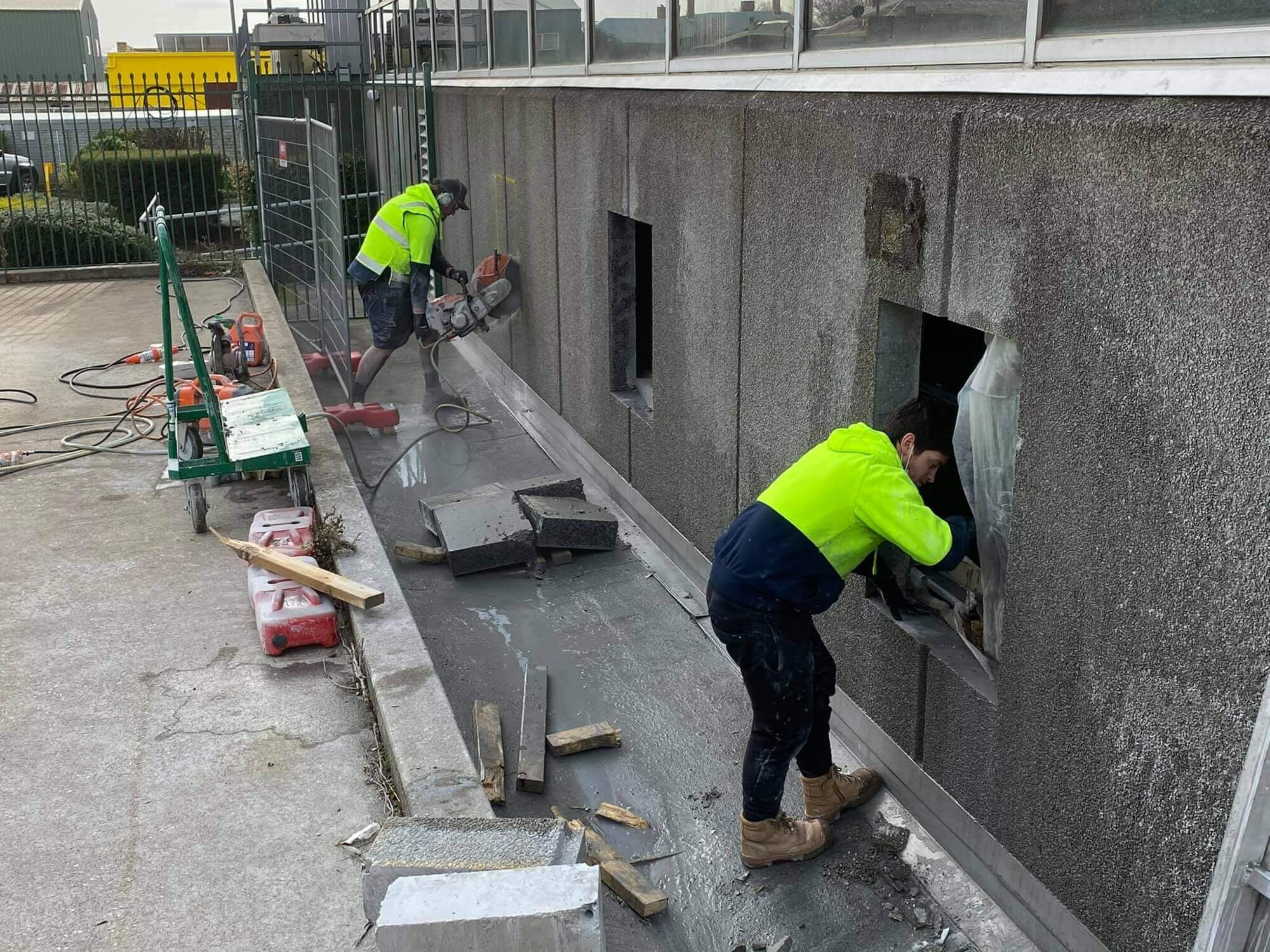 Track mounted wall saw cutting a square opening through a concrete wall