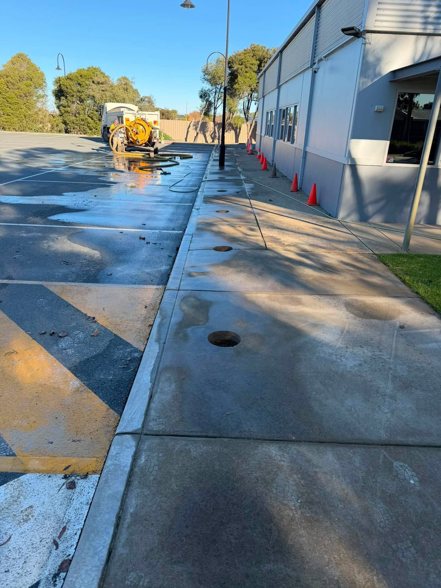 Row of completed core holes through a footpath, drilled clear of the services beneath