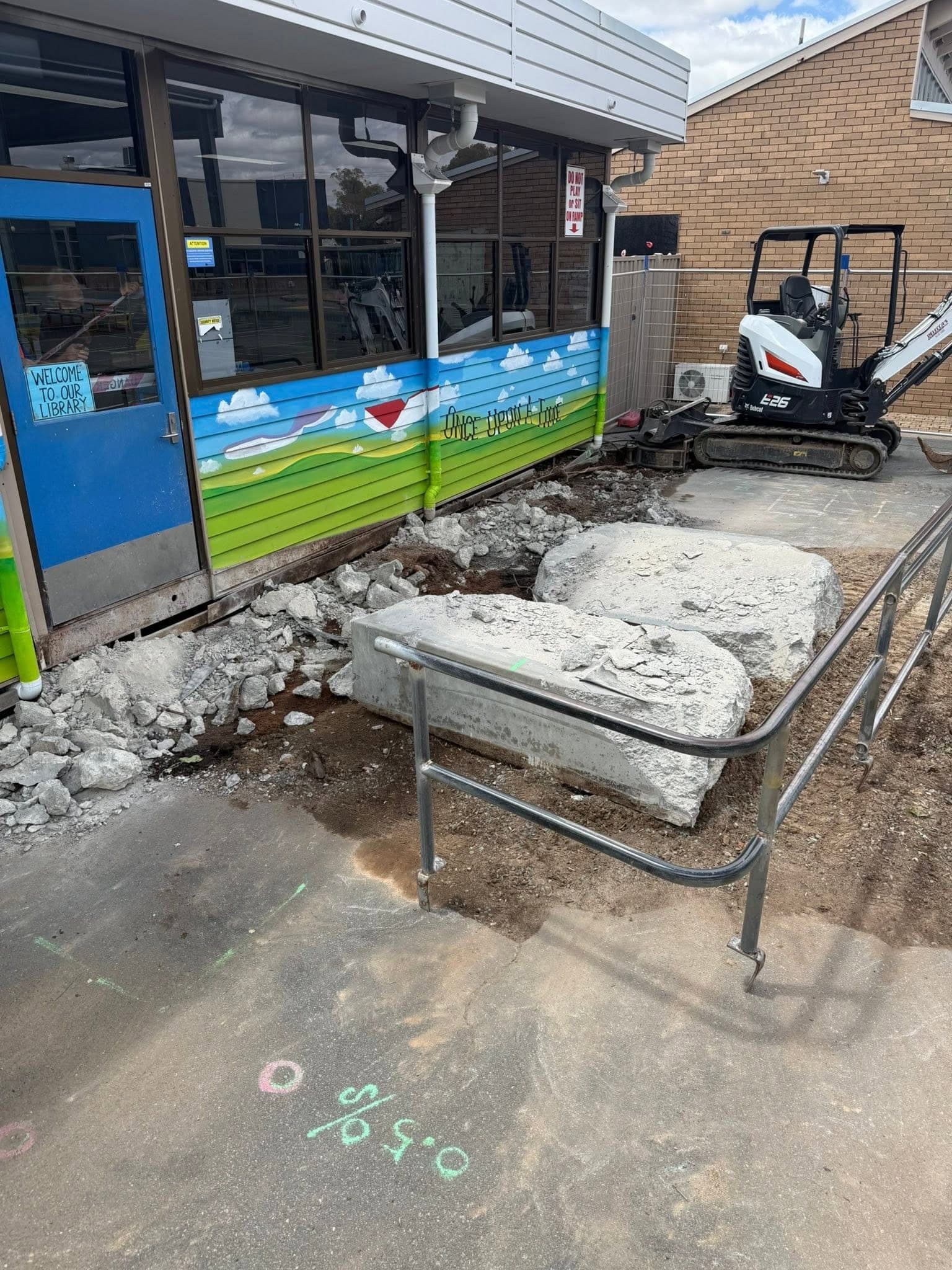 Saw cut slab sections lifted out of a shopfront floor and stacked for removal