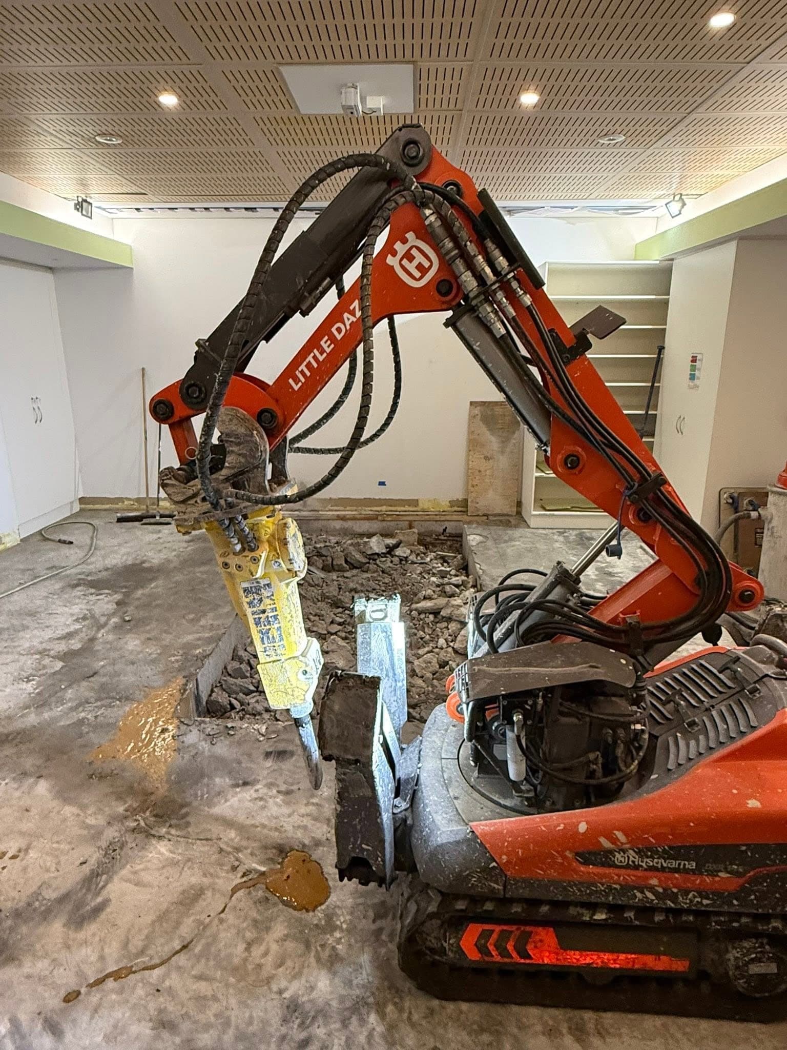 Husqvarna DXR 145 demolition robot breaking out a slab inside a fitted out building