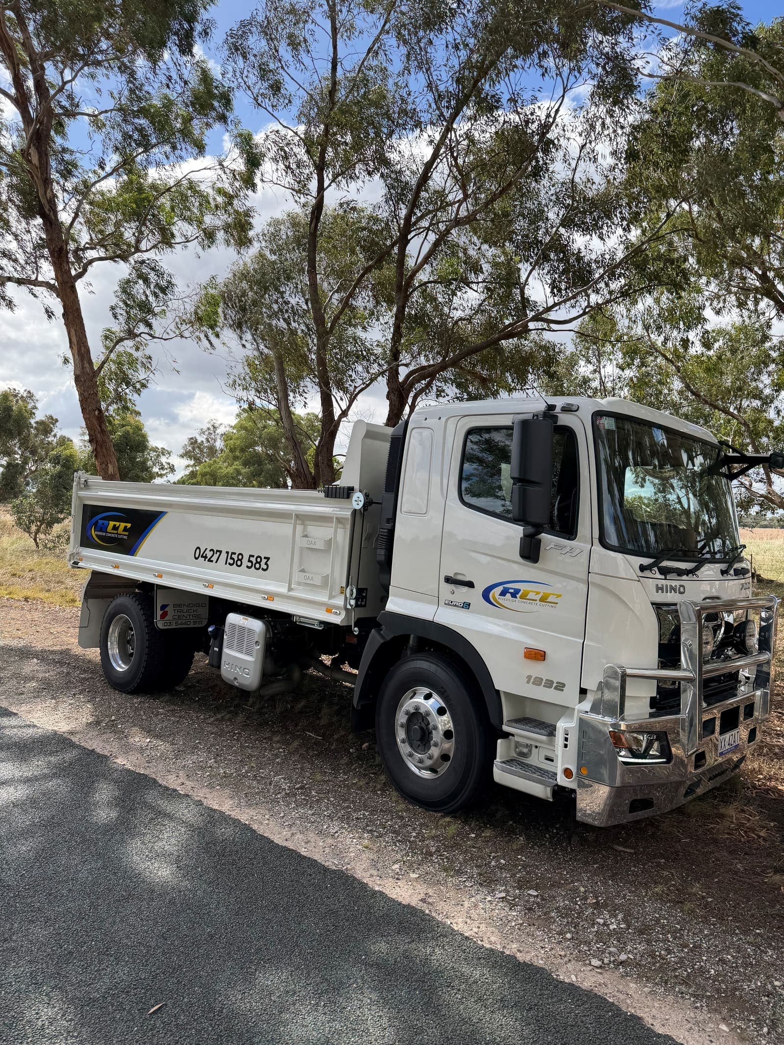 Riverside Concrete Cutting Hino 1832 tipper truck parked on a gravel roadside