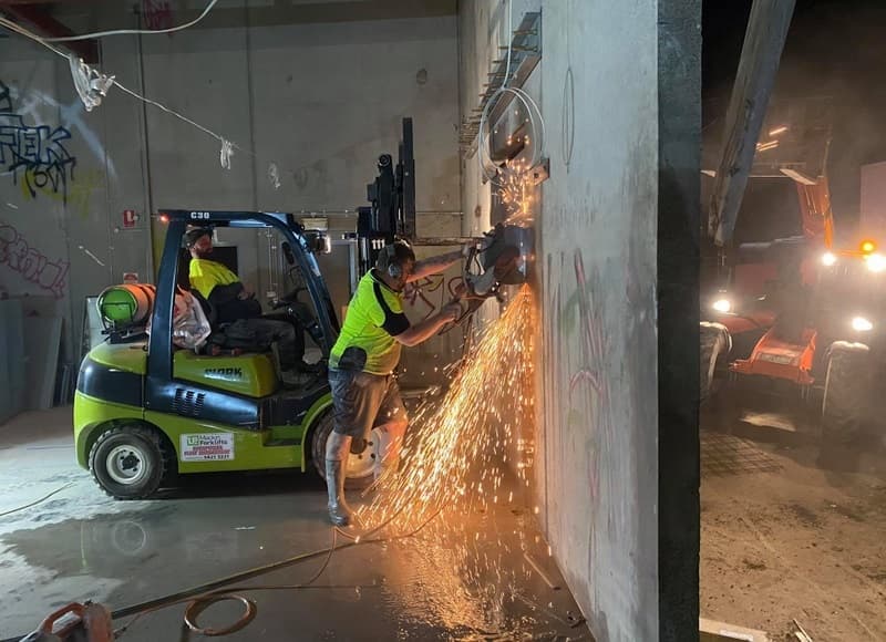 Handheld saw cutting a straight line into a concrete surface at close range