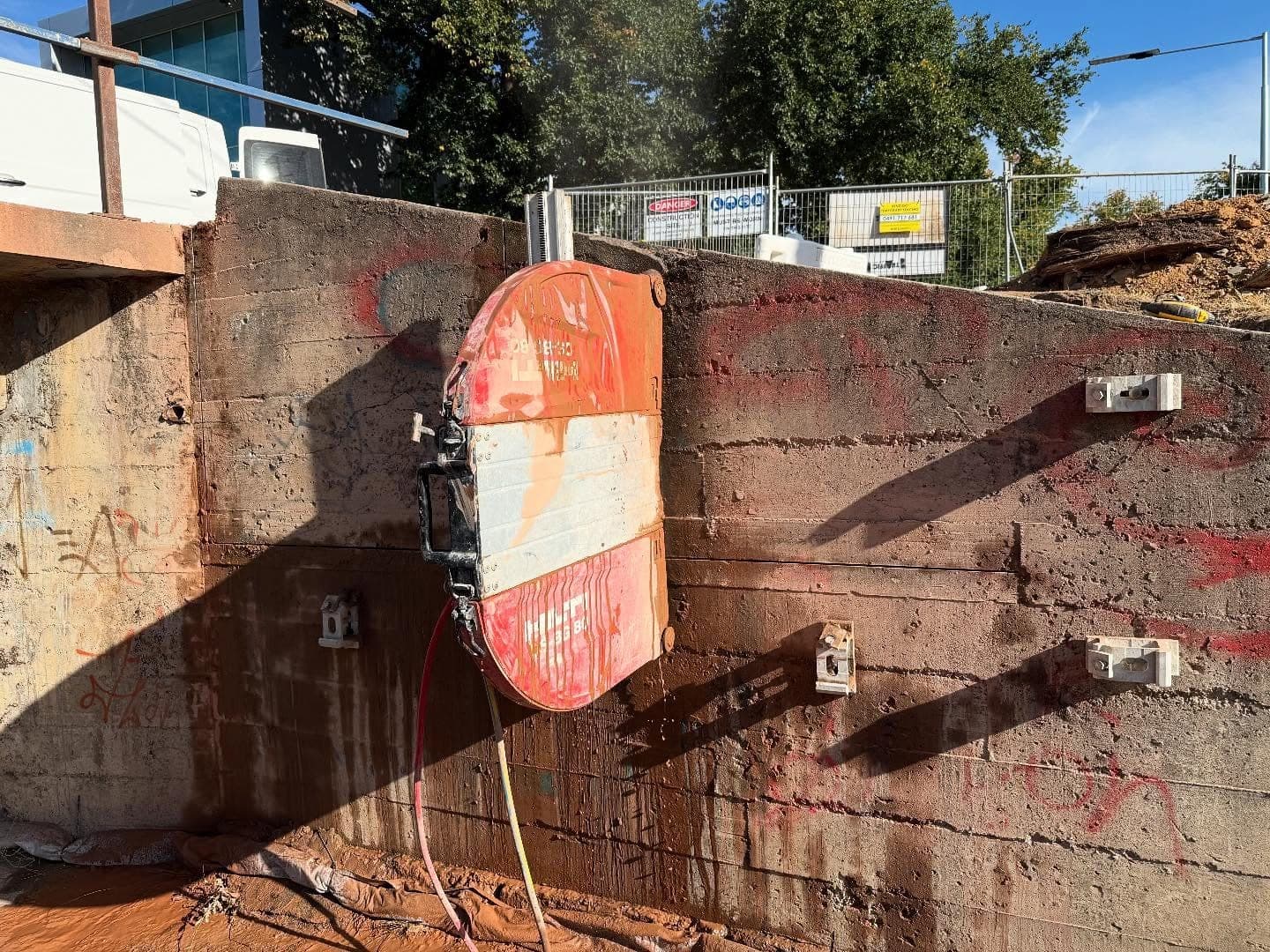 Track mounted wall saw bolted to a concrete retaining wall on a Bendigo site