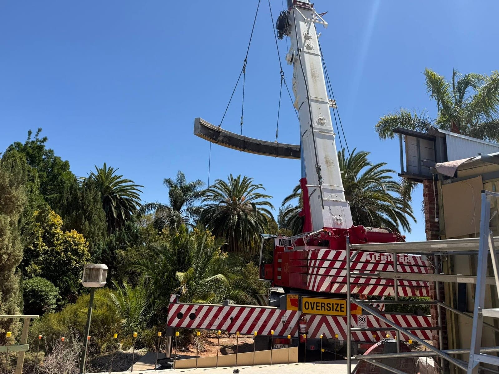 Crane lifting a curved concrete parapet section out in one piece after wire sawing
