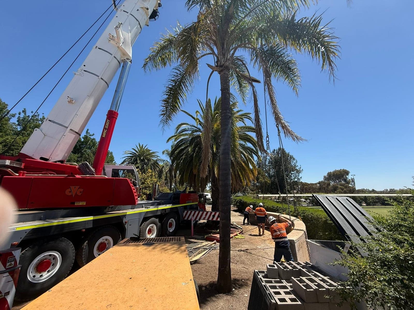 Crane set up over a concrete parapet section being taken apart by wire saw