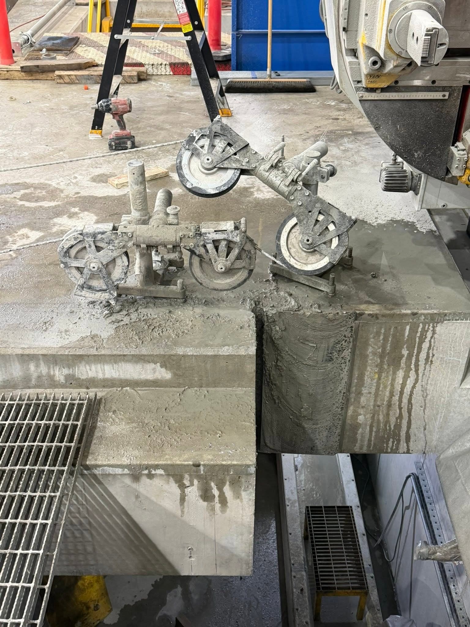 Hilti wire saw pulleys rigged over a concrete block section on an industrial floor